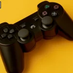 Black gaming controller on a yellow background with a logo in the corner. Can You Play MK One with One Controller on Switch? Explore how this controller might be used to play MK One efficiently on your Switch console.